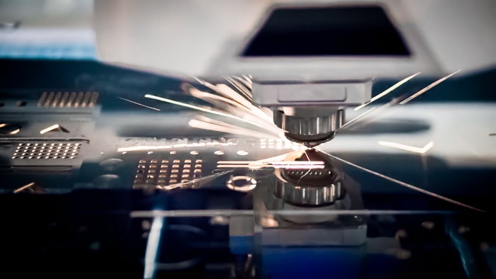Machine de découpe laser en train de découper une tôle dans l'atelier d'un sous-traitant tôlerie