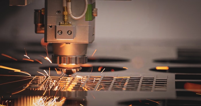Machine de découpe laser en train de découper une tôle dans un atelier de tolerie fine industrielle